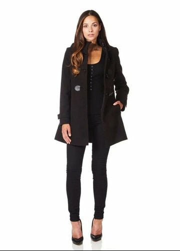 Woman wearing a black coat and pants on a white background