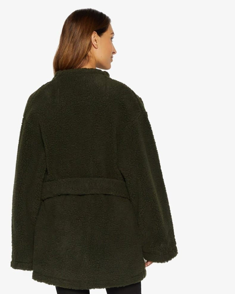 Woman wearing a dark green coat on a white background
