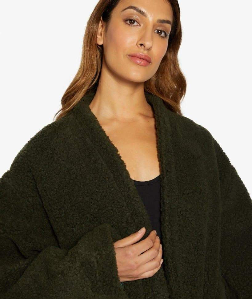 Woman wearing a dark green coat on a white background