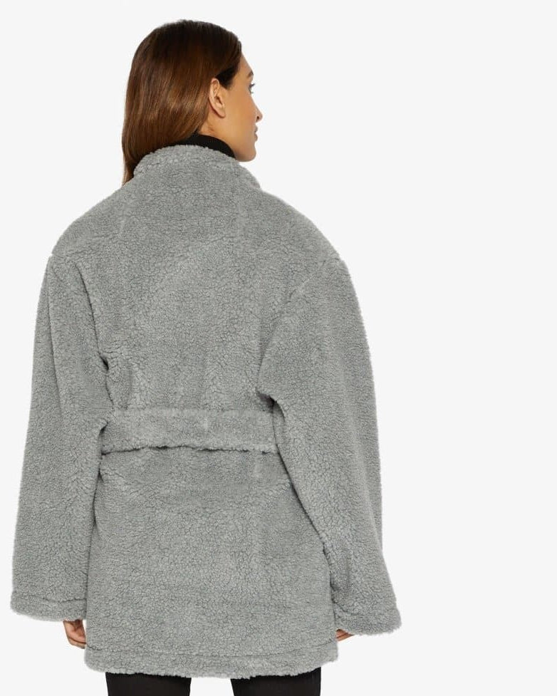 Woman wearing a gray robe with a belt on a white background