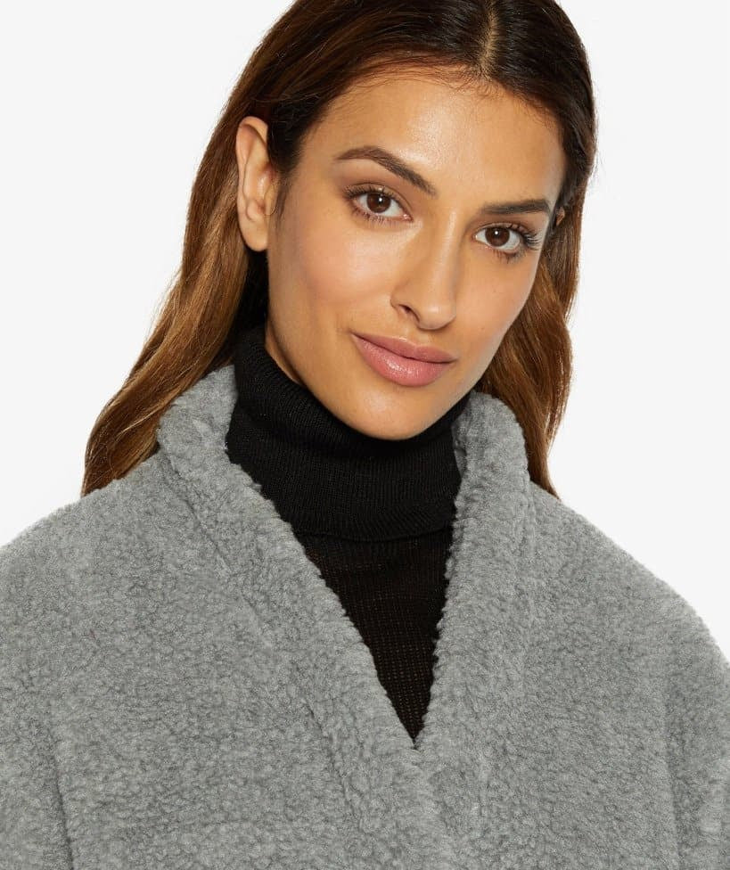 Woman wearing a gray coat over a black turtleneck