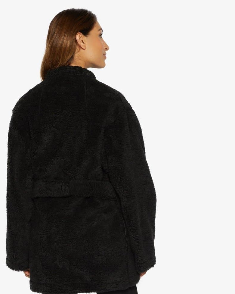 Woman wearing a black fleece jacket on a white background