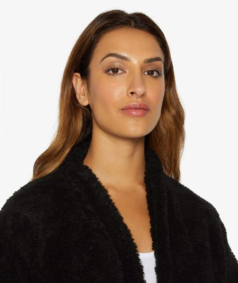 Woman wearing a black robe with a plain background