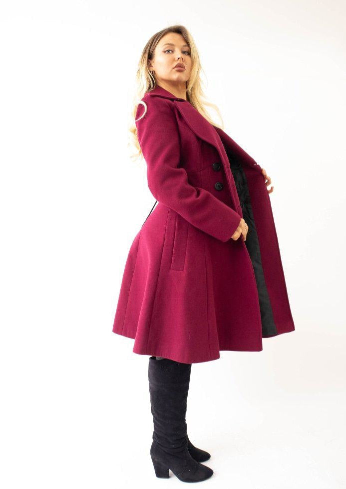 Woman wearing a pink coat with black accents on a white background