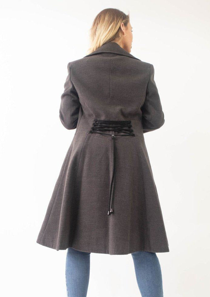 Woman wearing a gray coat with a belt on a white background