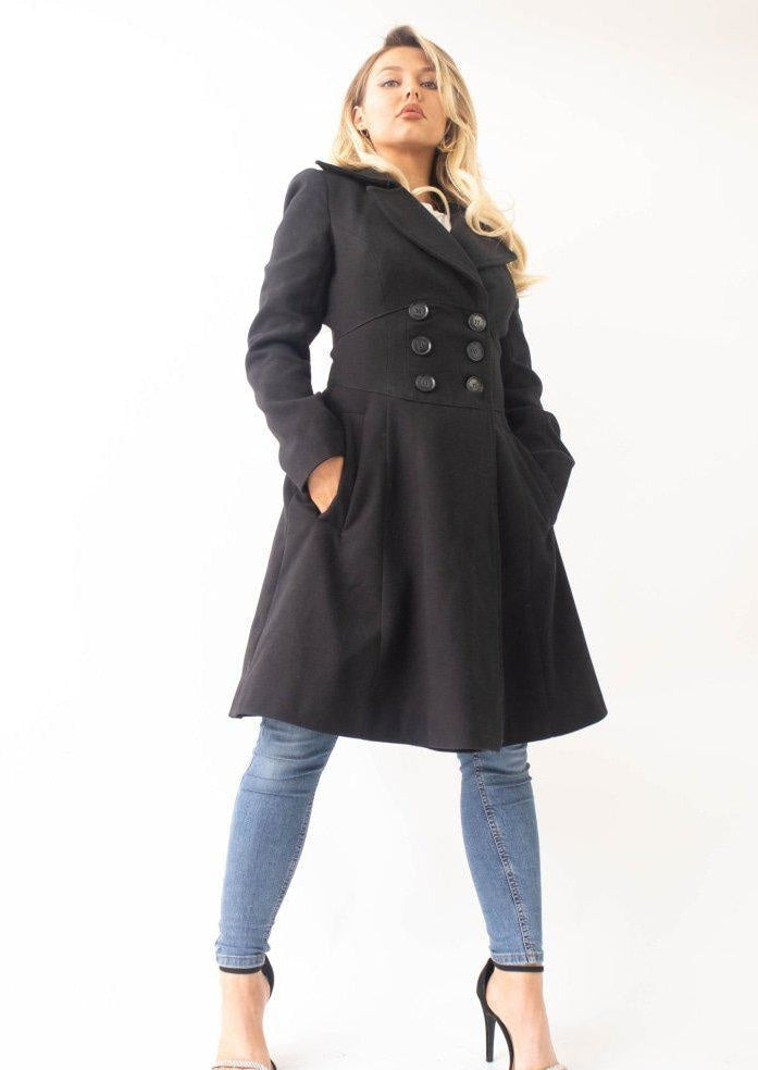Woman wearing a black coat and blue jeans on a white background
