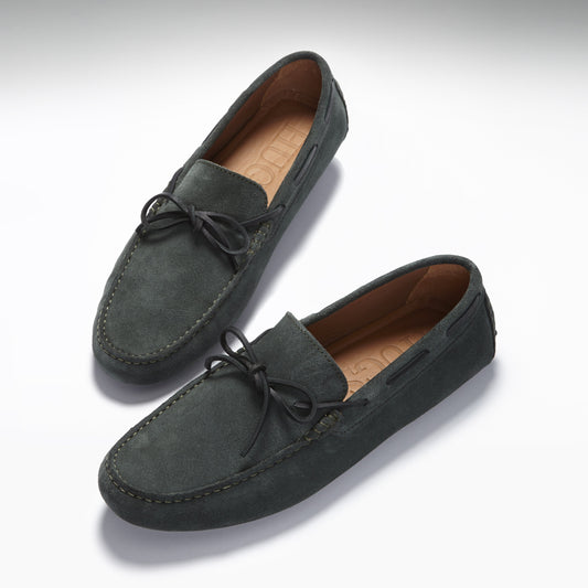 Pair of green suede loafers on a white background