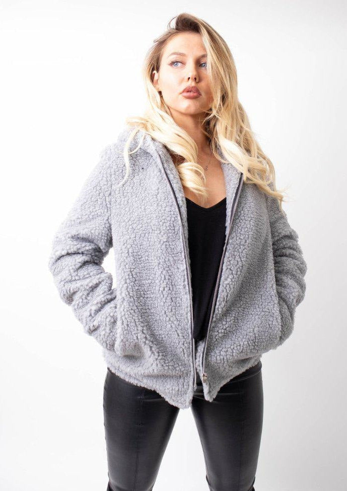 Woman wearing a gray fleece jacket on a white background