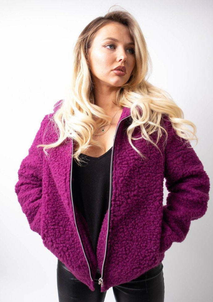 Woman wearing a purple fleece jacket on a white background
