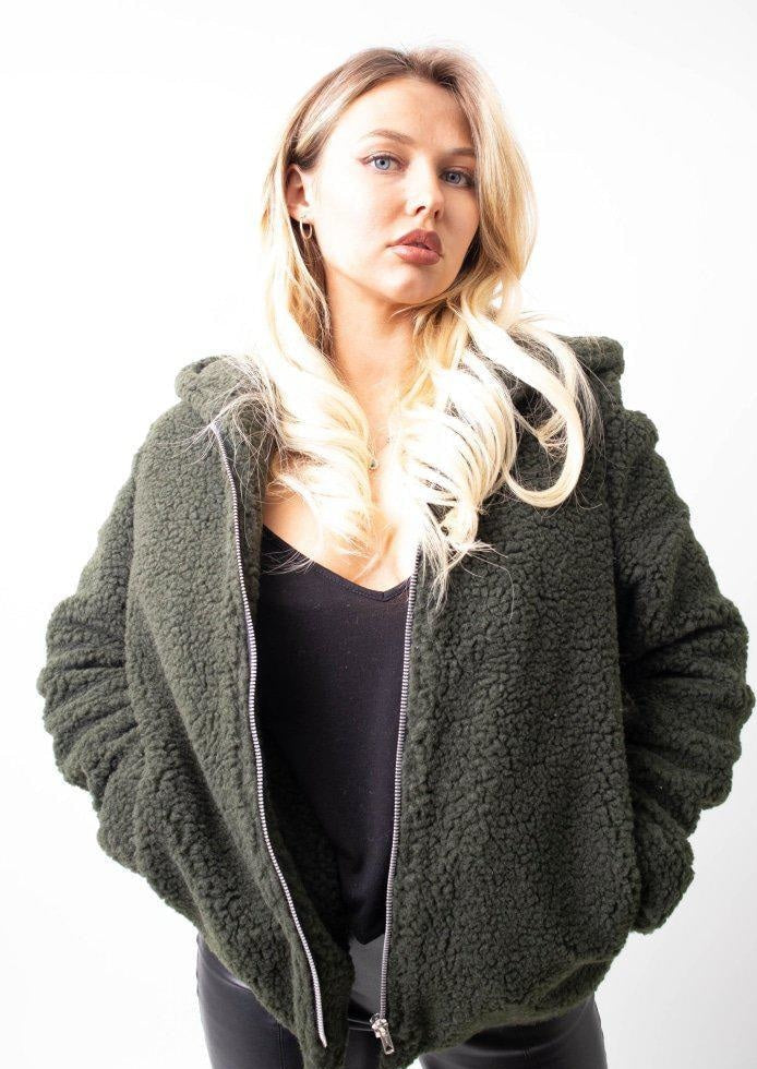 Woman wearing a green fleece jacket on a white background