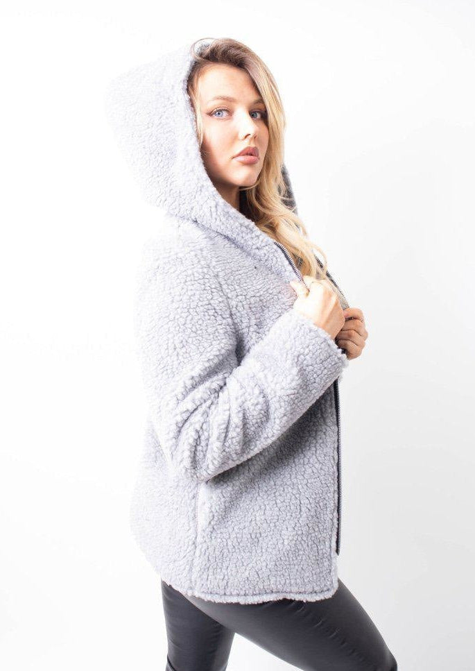 Woman wearing a gray fleece jacket on a white background