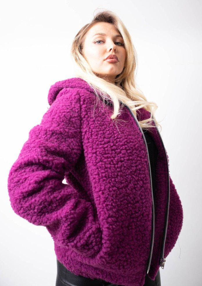 Woman wearing a purple textured jacket against a white background