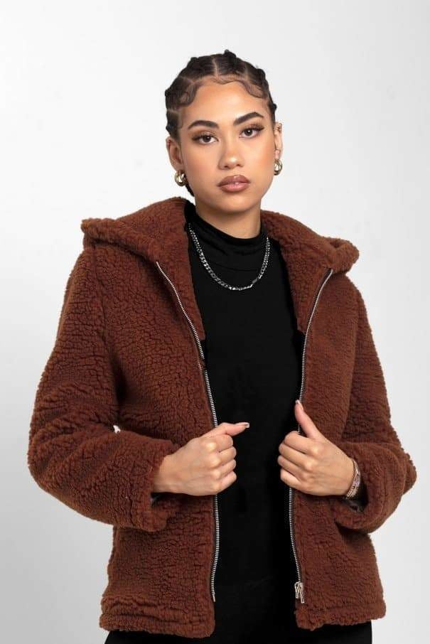 Woman wearing a brown hooded jacket on a white background