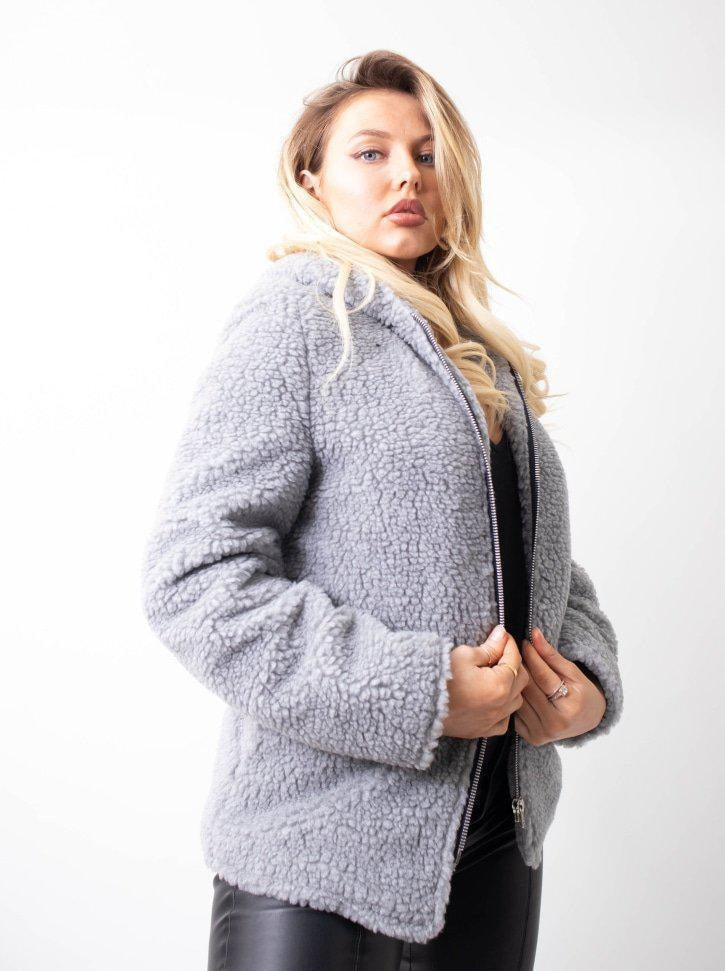 Woman wearing a gray textured cardigan on a white background