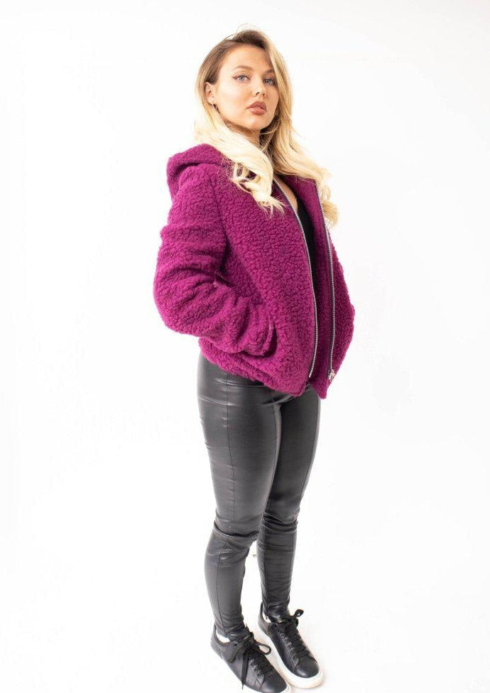 Woman wearing a purple hoodie and black pants on a white background