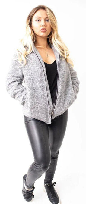 Woman wearing a gray jacket and black pants on a white background