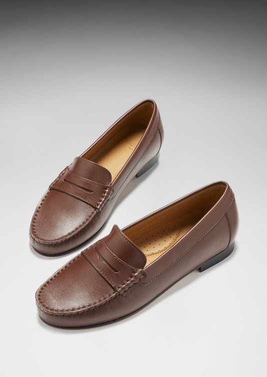 Pair of brown leather loafers on a light gray background