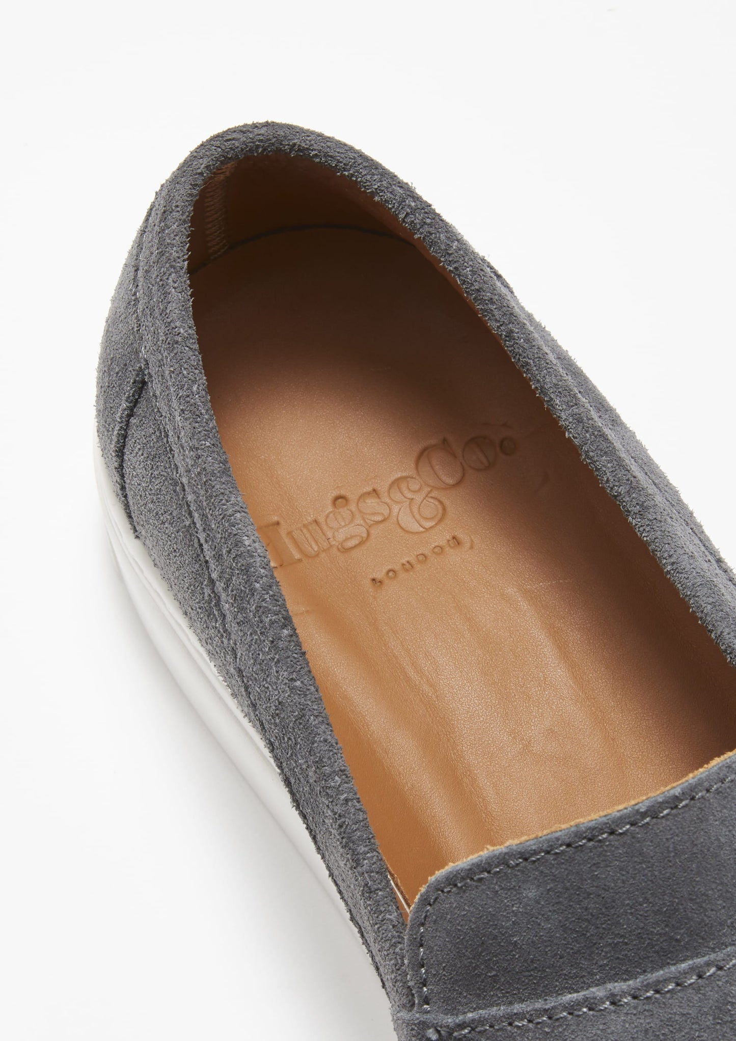 Gray suede loafer with a tan insole on a white background