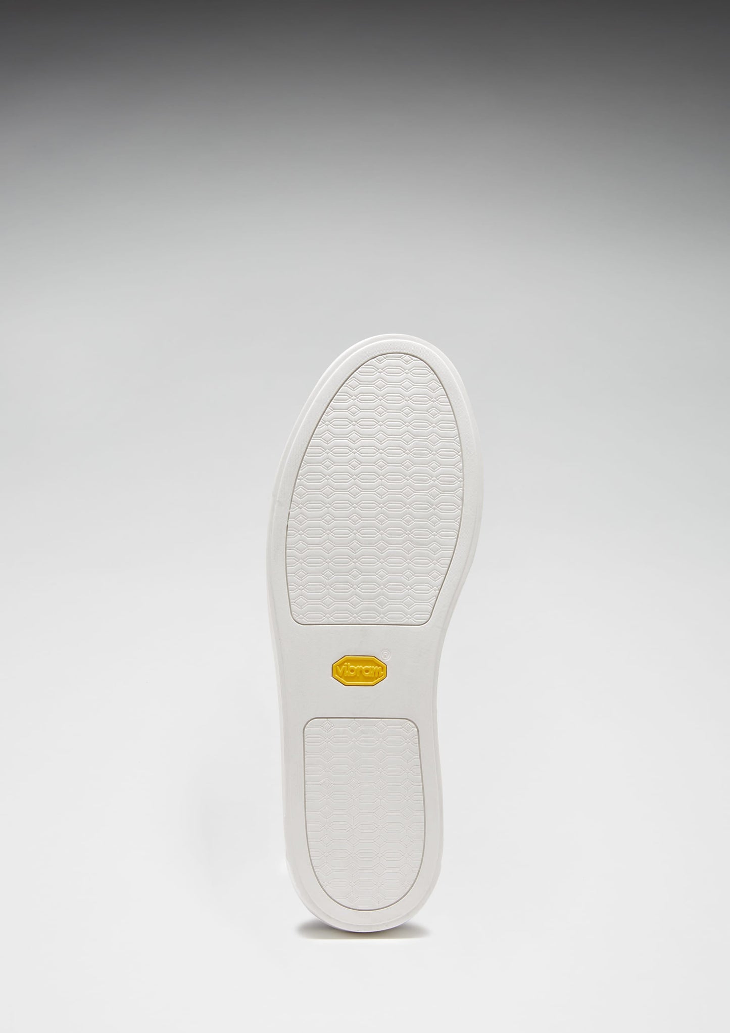 White shoe sole with a brand logo on a gray background