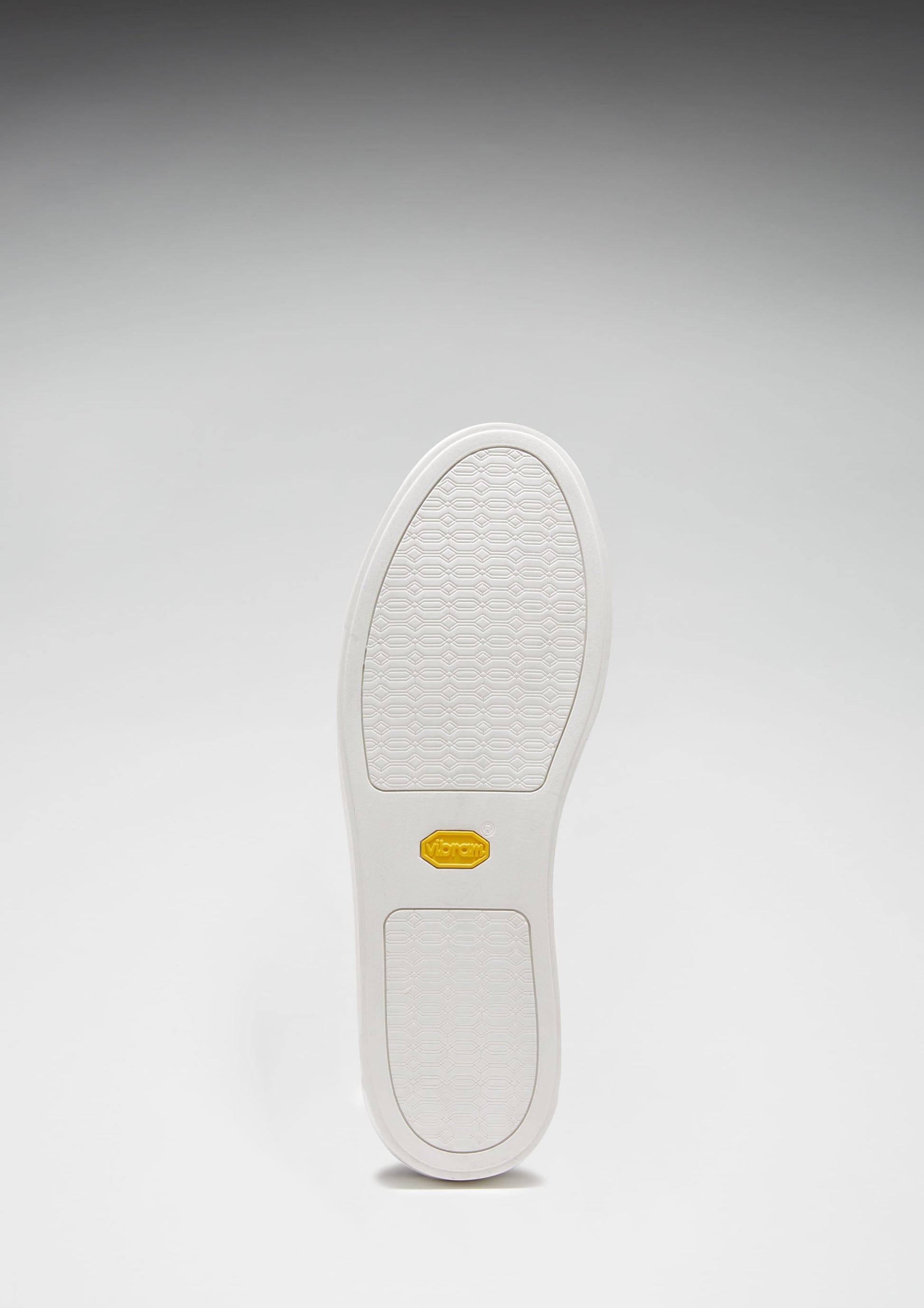 White shoe sole with a brand logo on a gray background