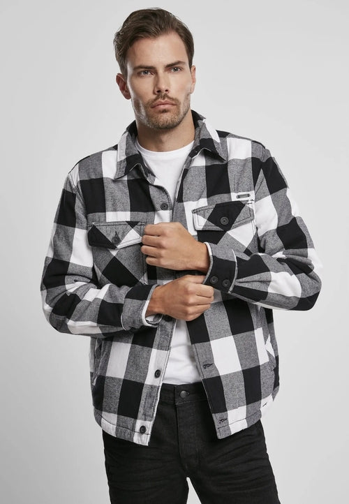 Man wearing a black and white checkered shirt on a gray background