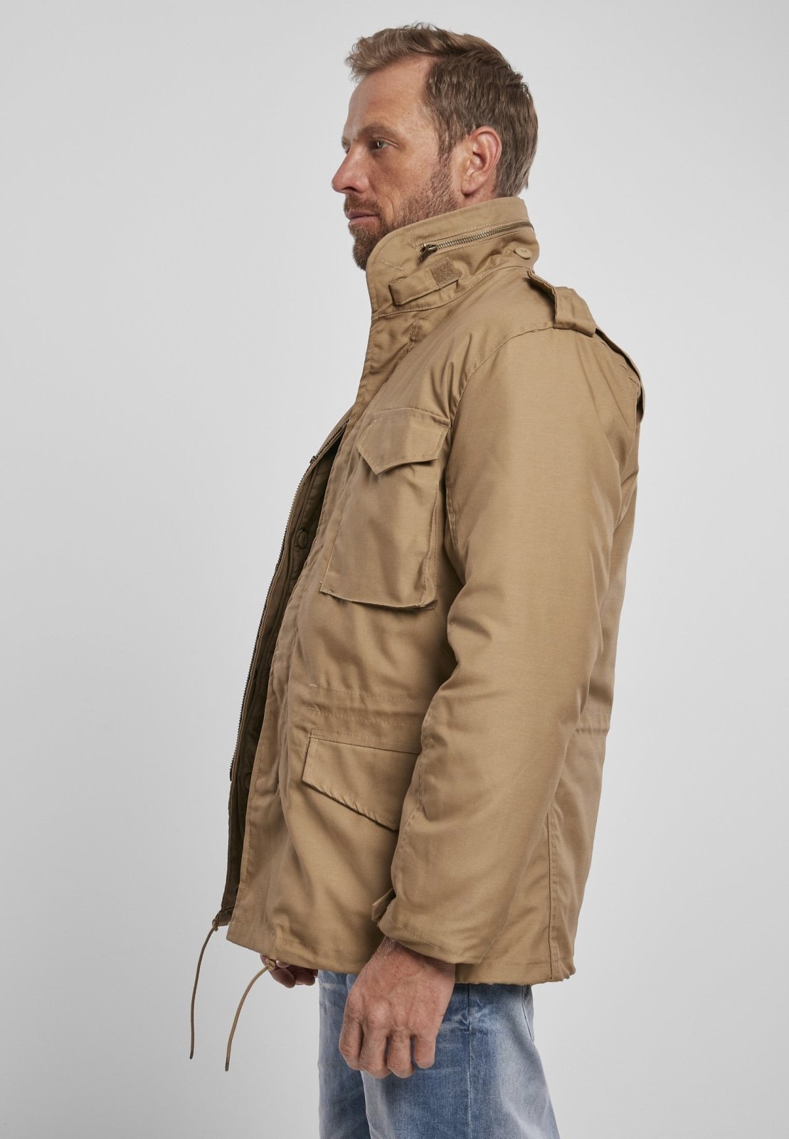 Man wearing a beige parka jacket on a white background