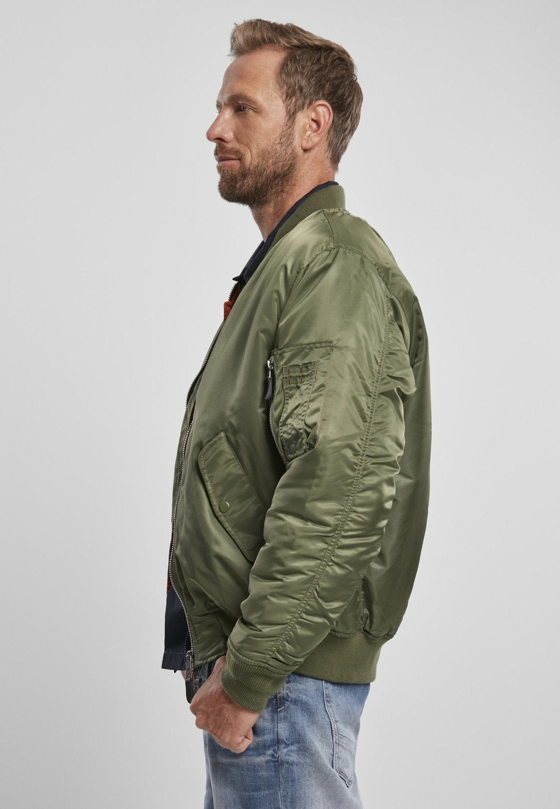 Man wearing a green bomber jacket on a white background
