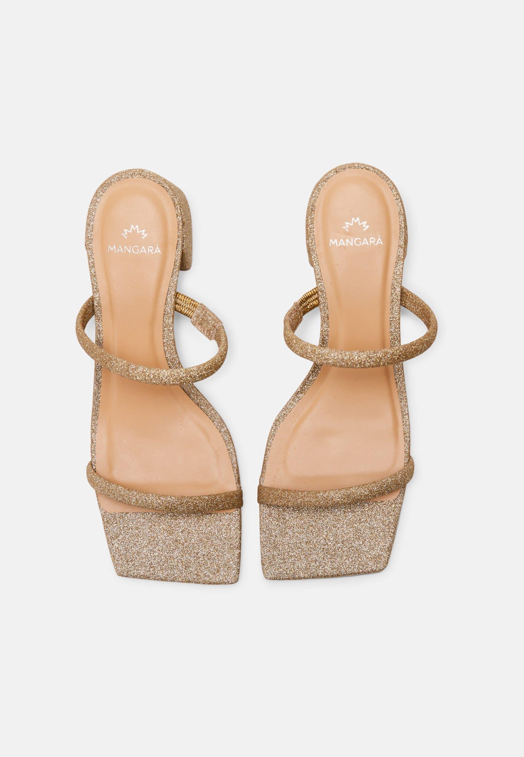 Gold glitter high-heeled sandals on a white background