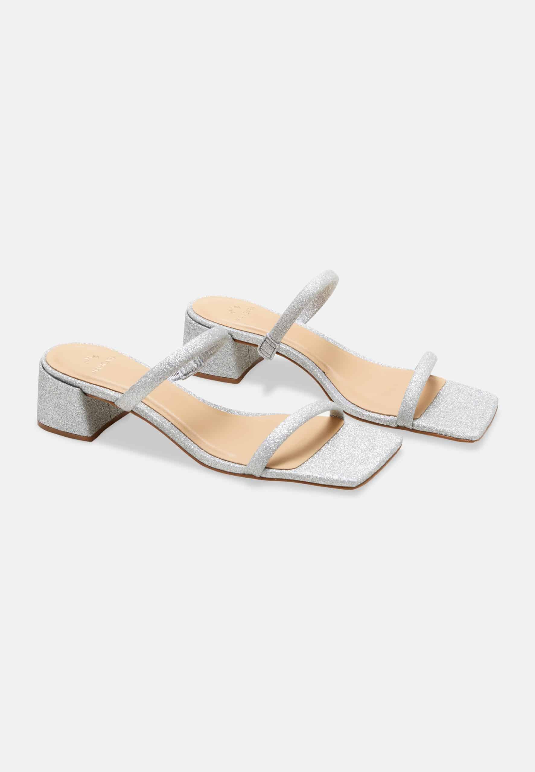 Silver strappy sandals on a white background