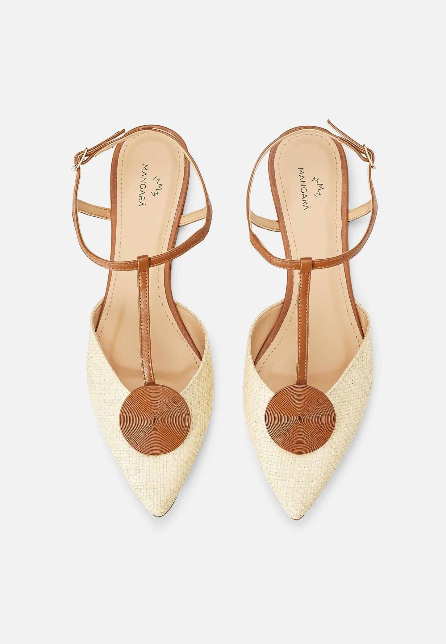 Pair of pointed-toe shoes with tan straps and beige fabric on a light gray background