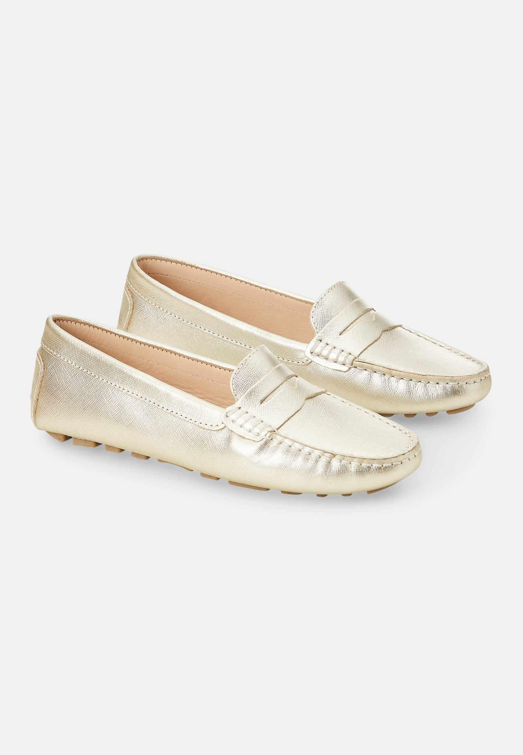 Pair of gold loafers on a white background