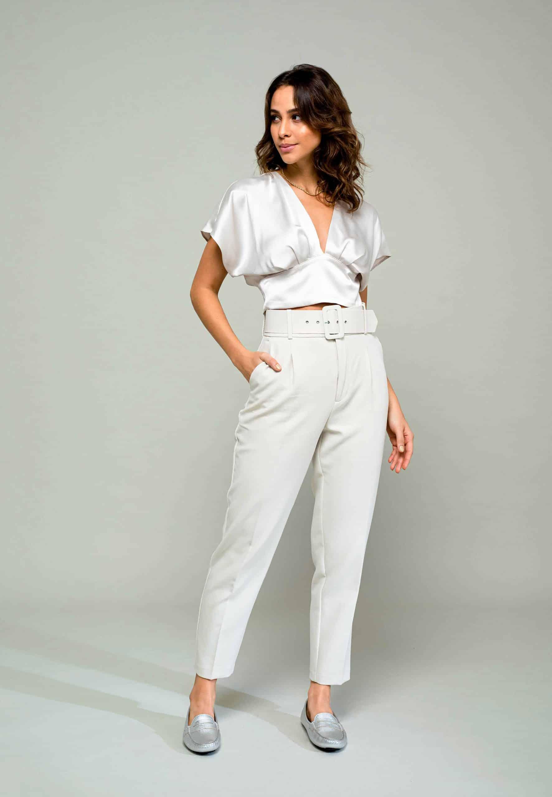 Woman wearing a white outfit with a plain background