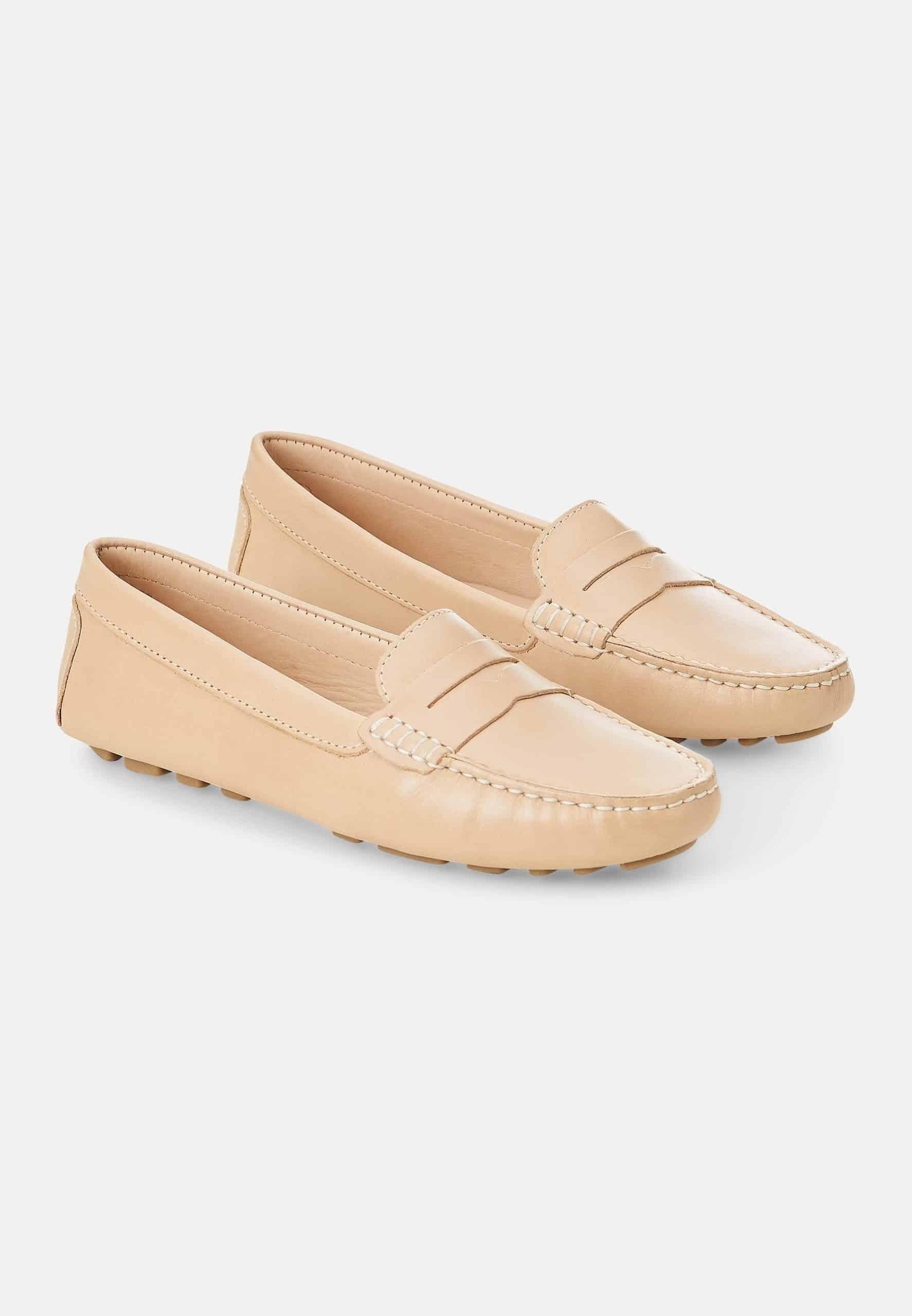 Pair of beige loafers on a light gray background