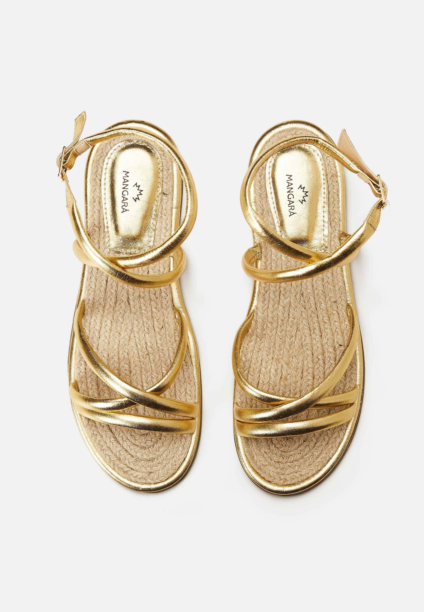 Pair of gold sandals with criss-cross straps on a white background