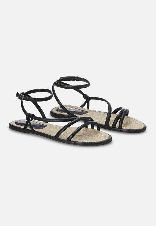 Black strappy sandals on a white background
