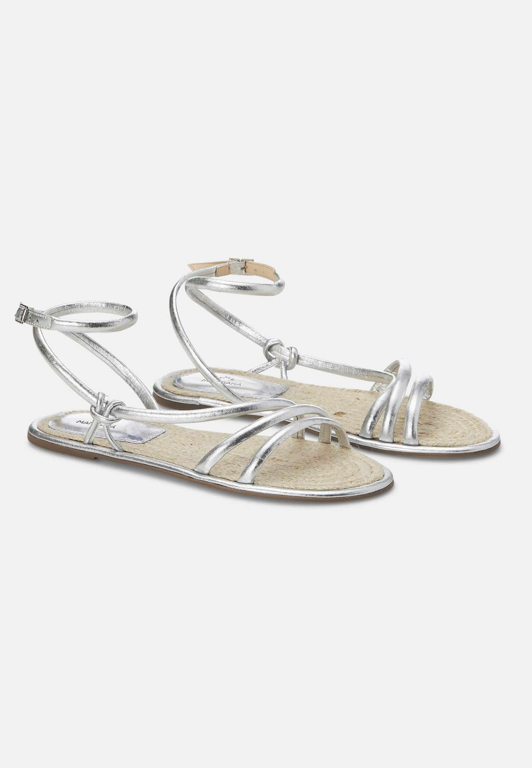 Pair of silver sandals on a white background