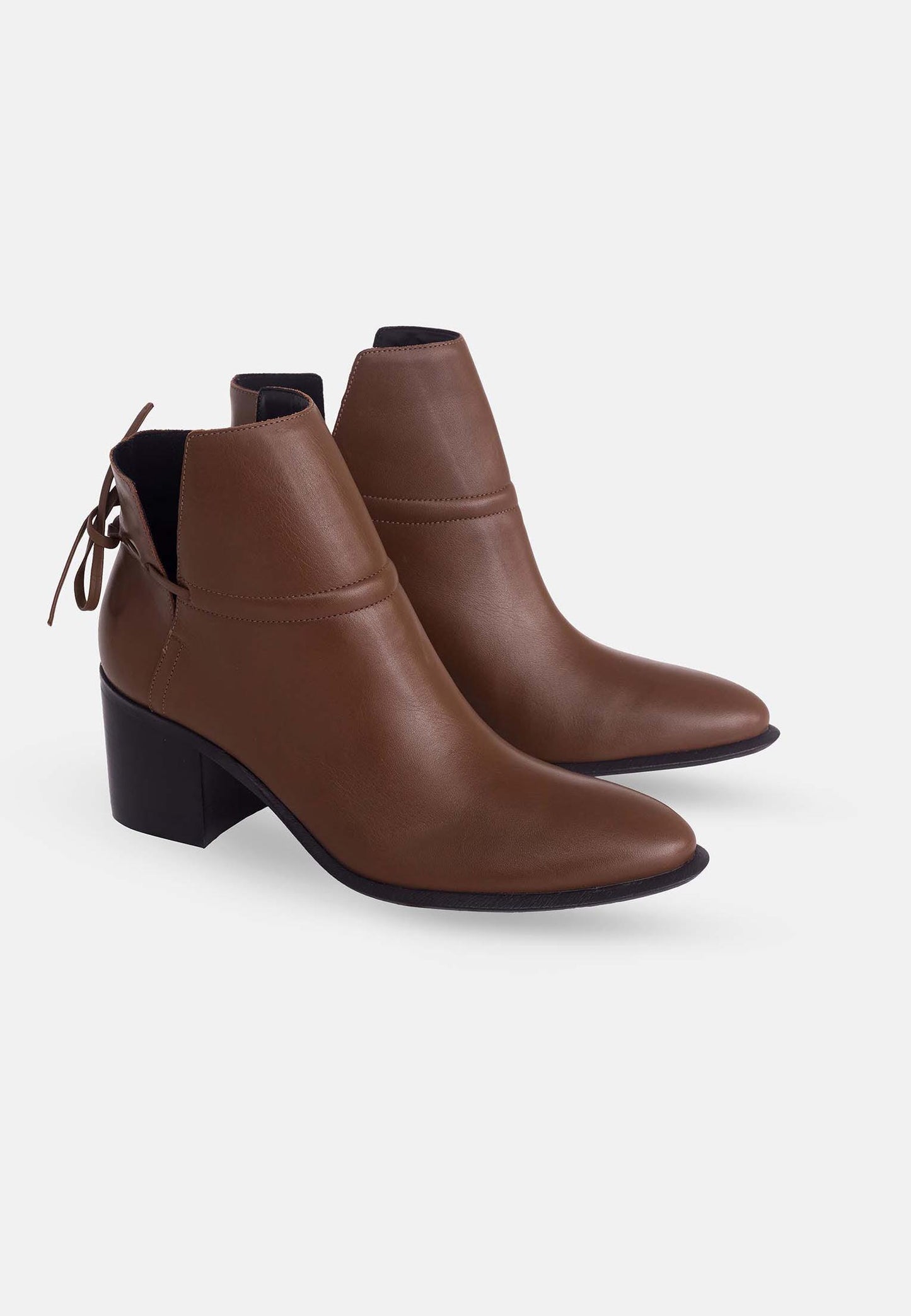 Pair of brown ankle boots with black soles on a white background
