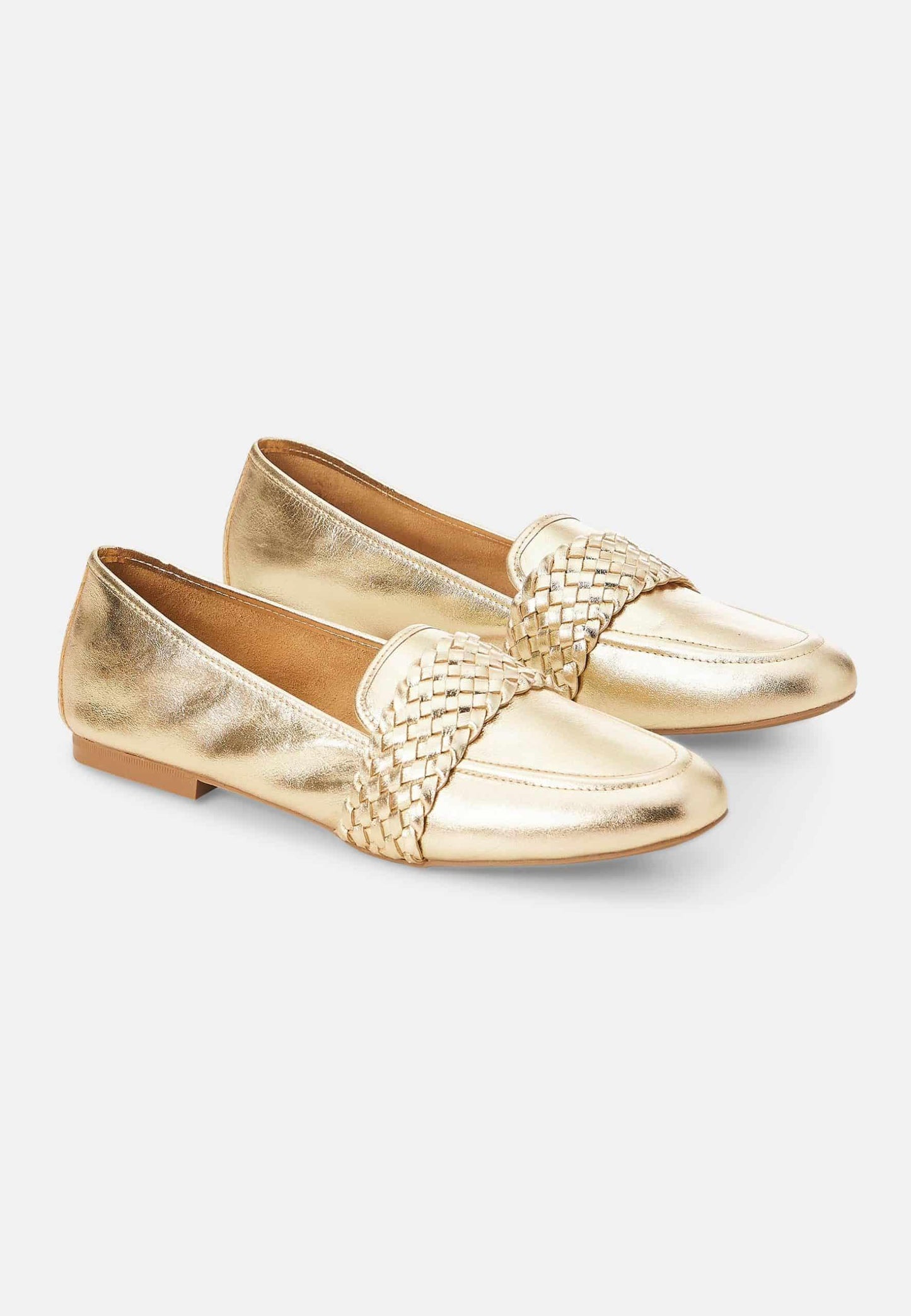 Gold loafers with woven detail on a light gray background