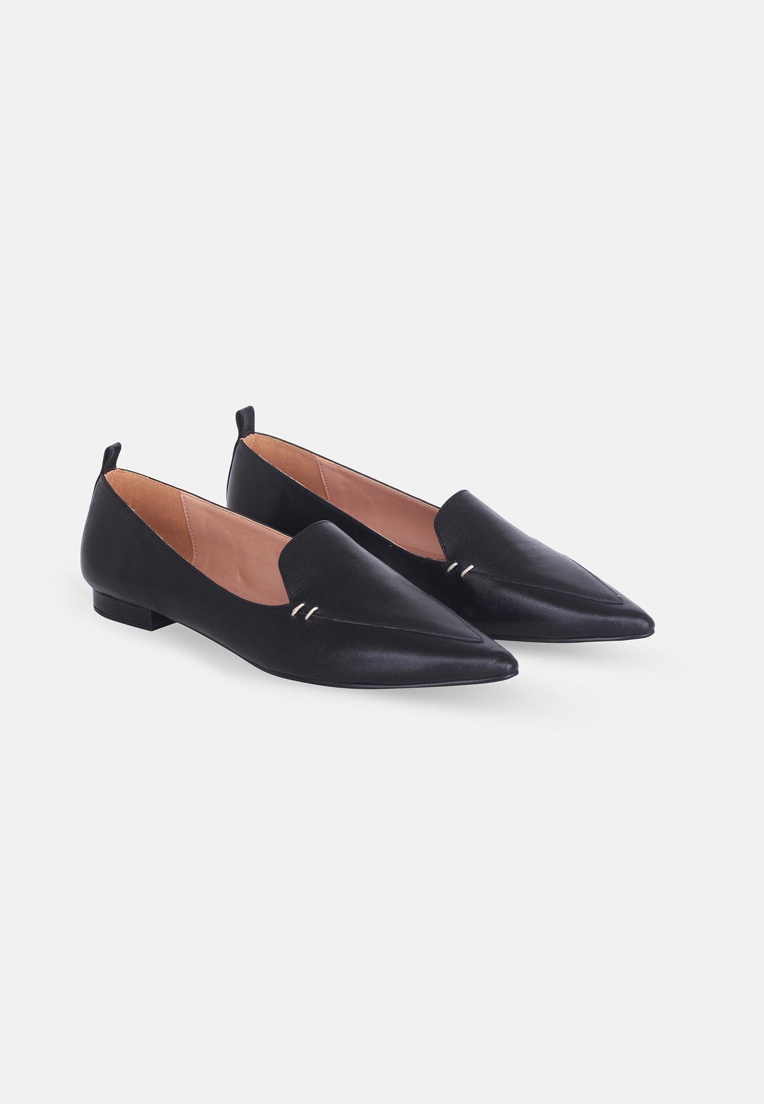 Pair of black pointed-toe flats on a white background
