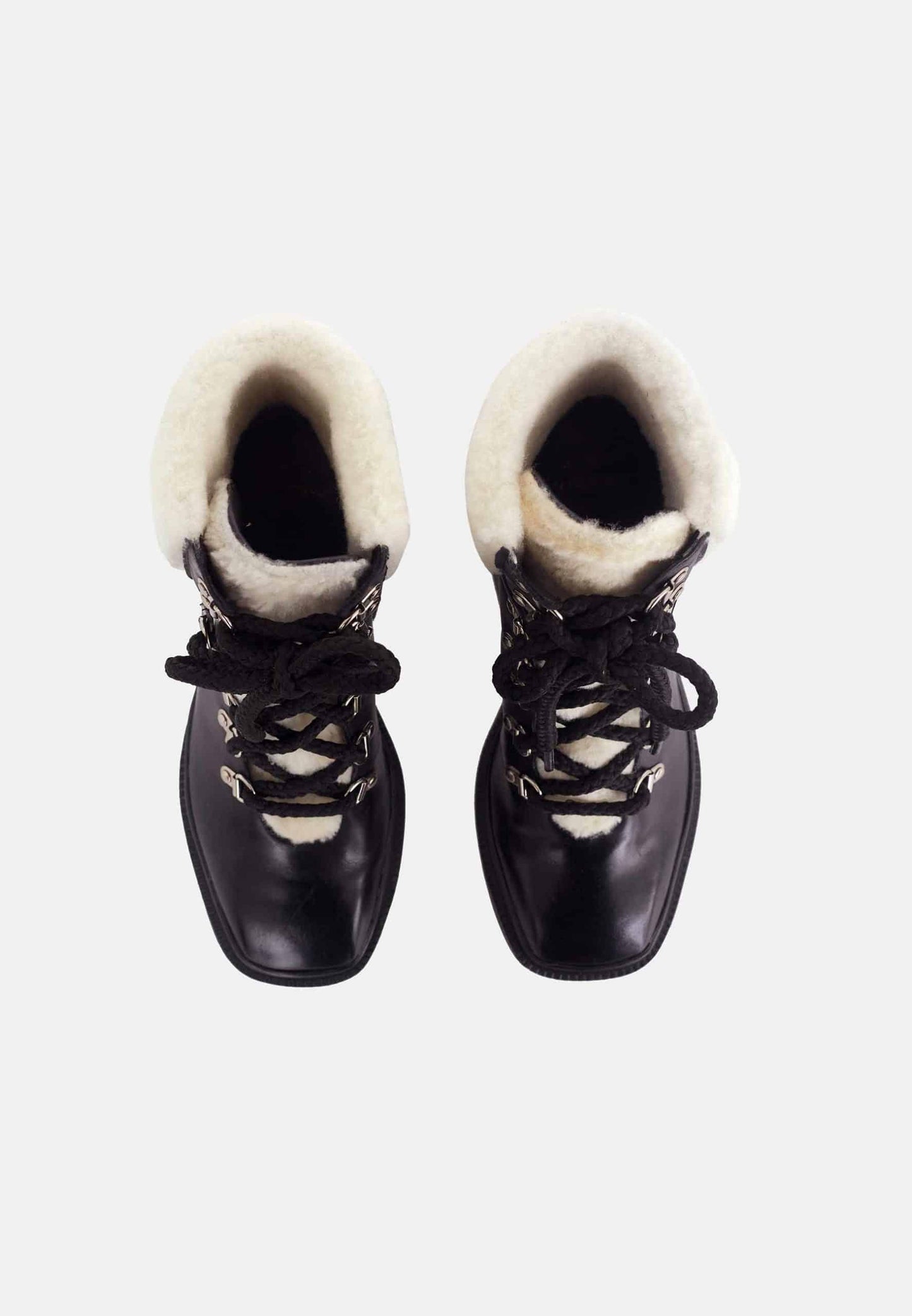 Pair of black boots with white fur lining on a white background