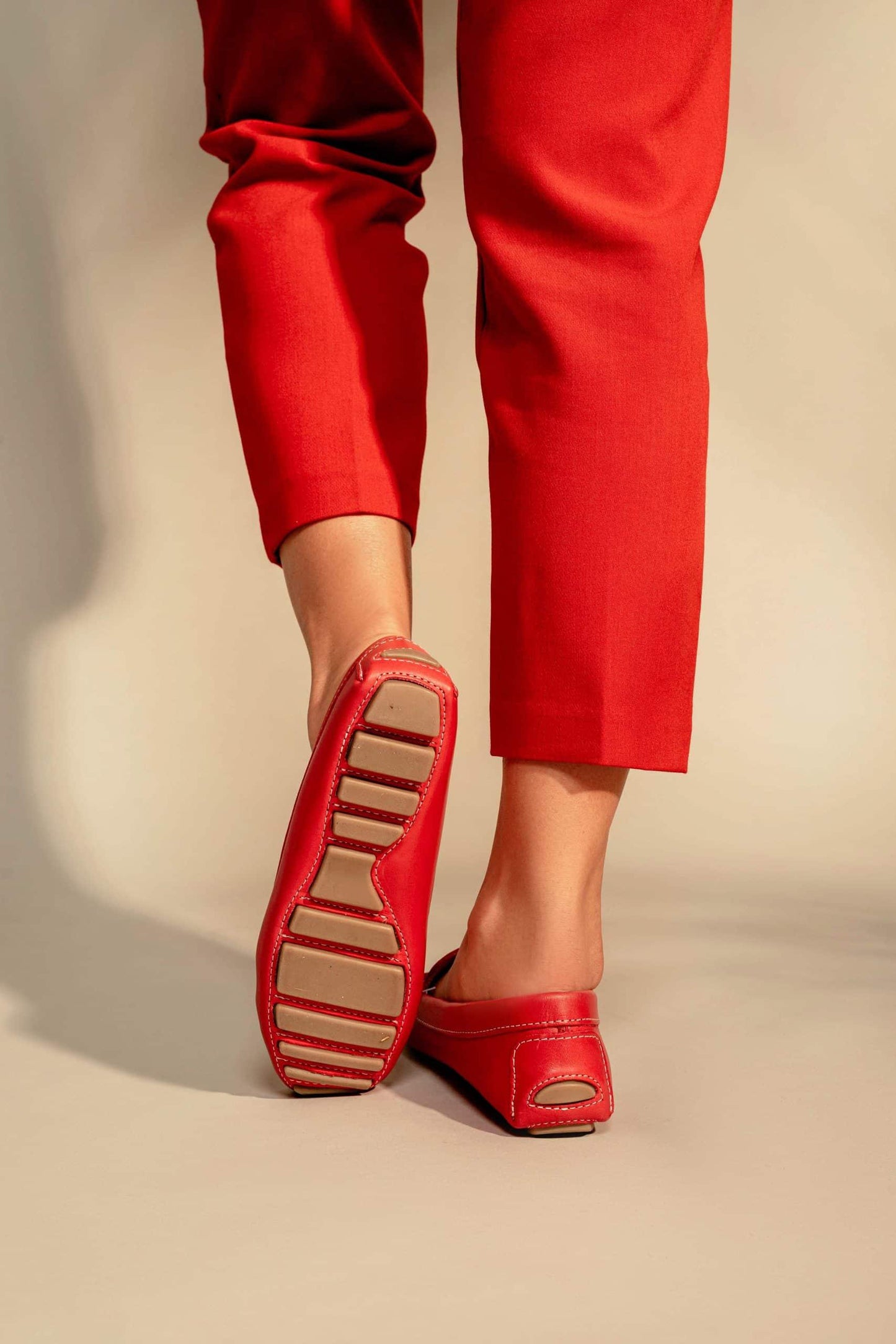 Red shoes and red pants on a beige background