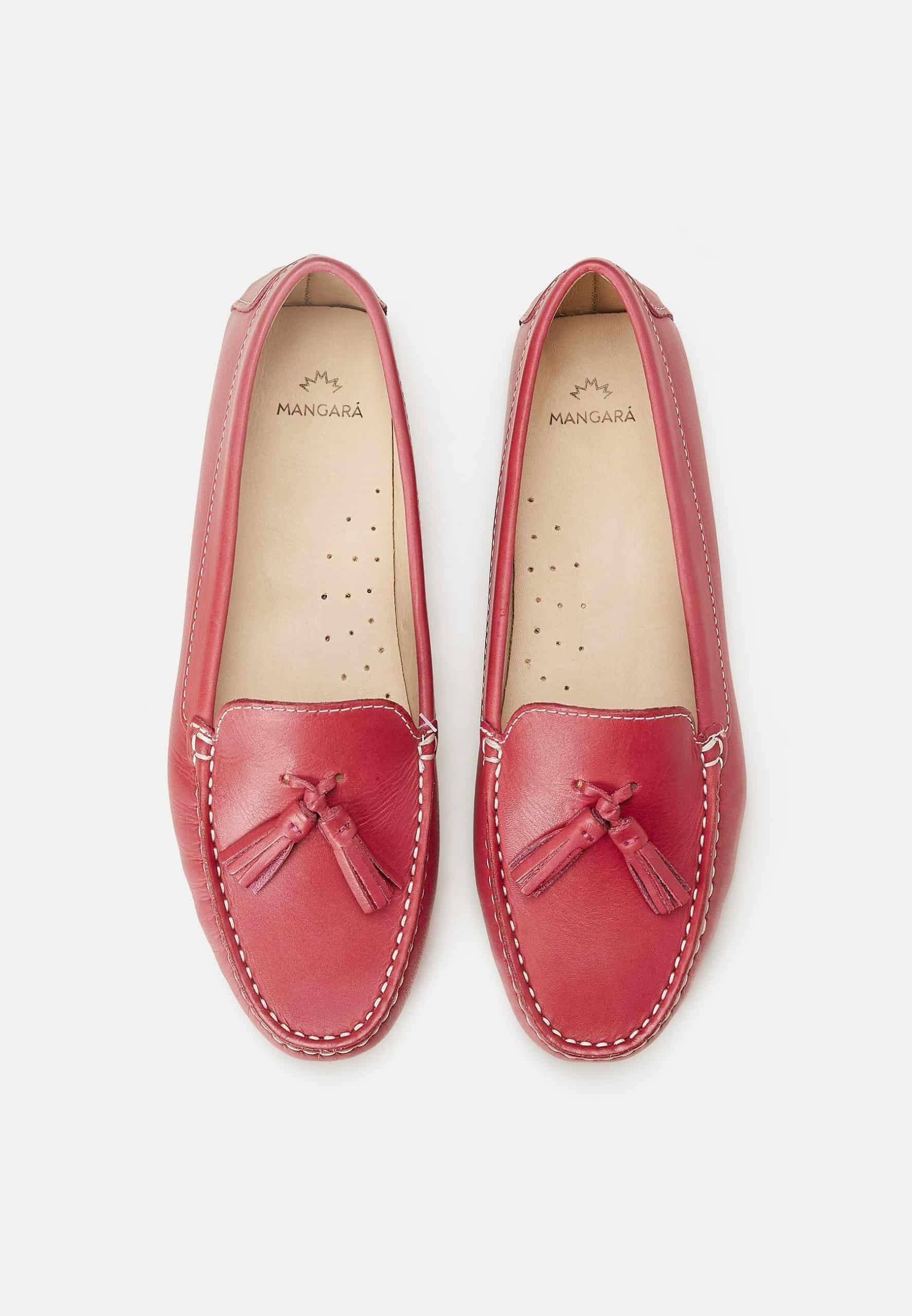 Pair of red loafers with tassels on a white background