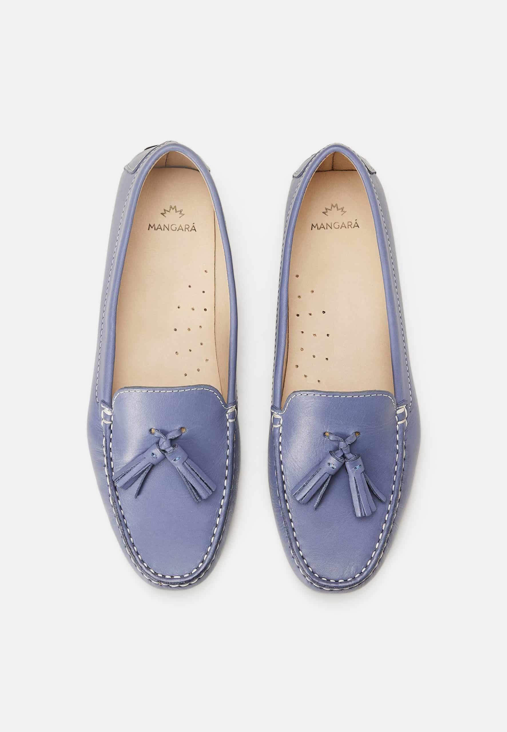 Pair of light blue loafers with tassels on a white background