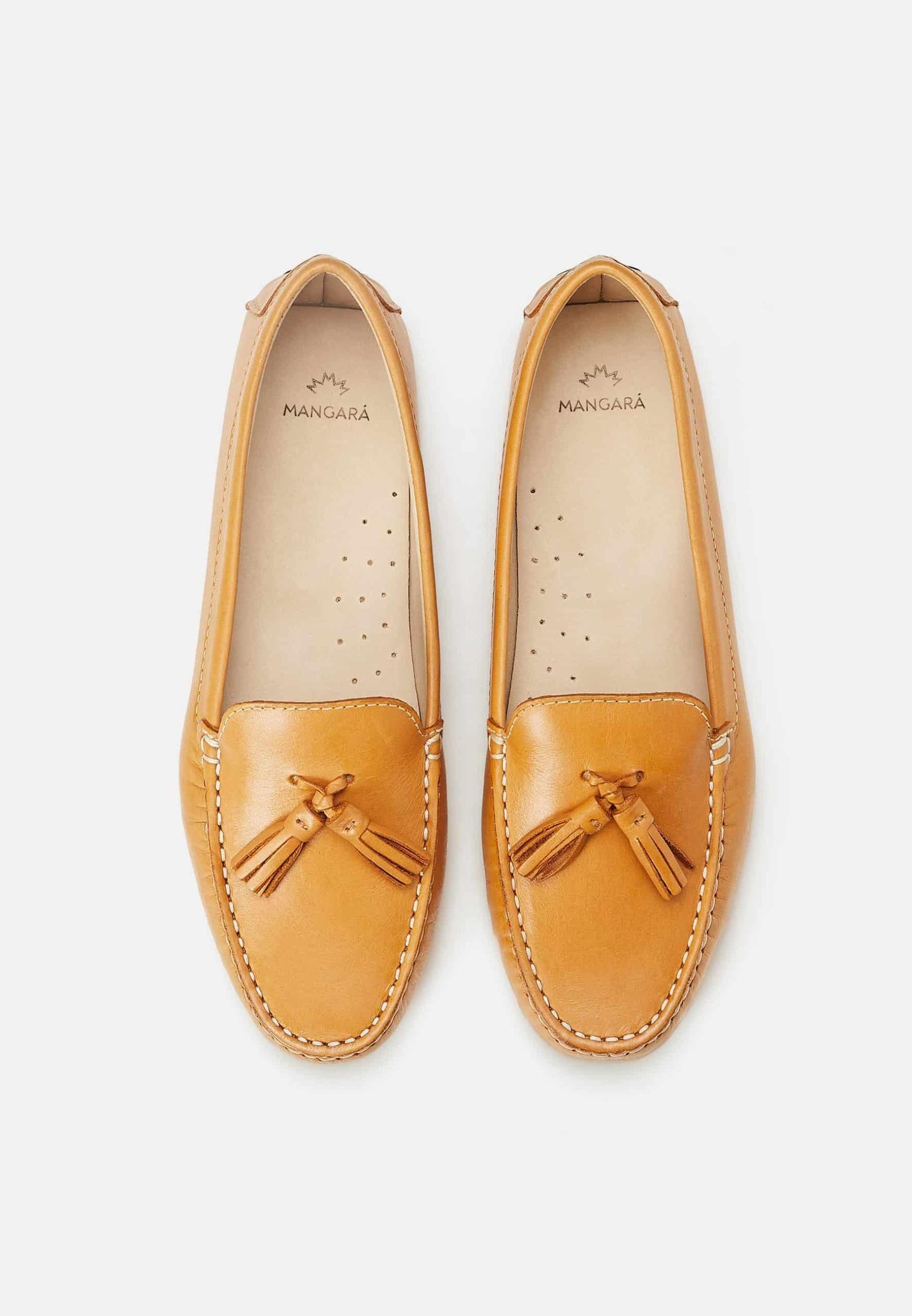 Pair of tan loafers with tassels on a light gray background