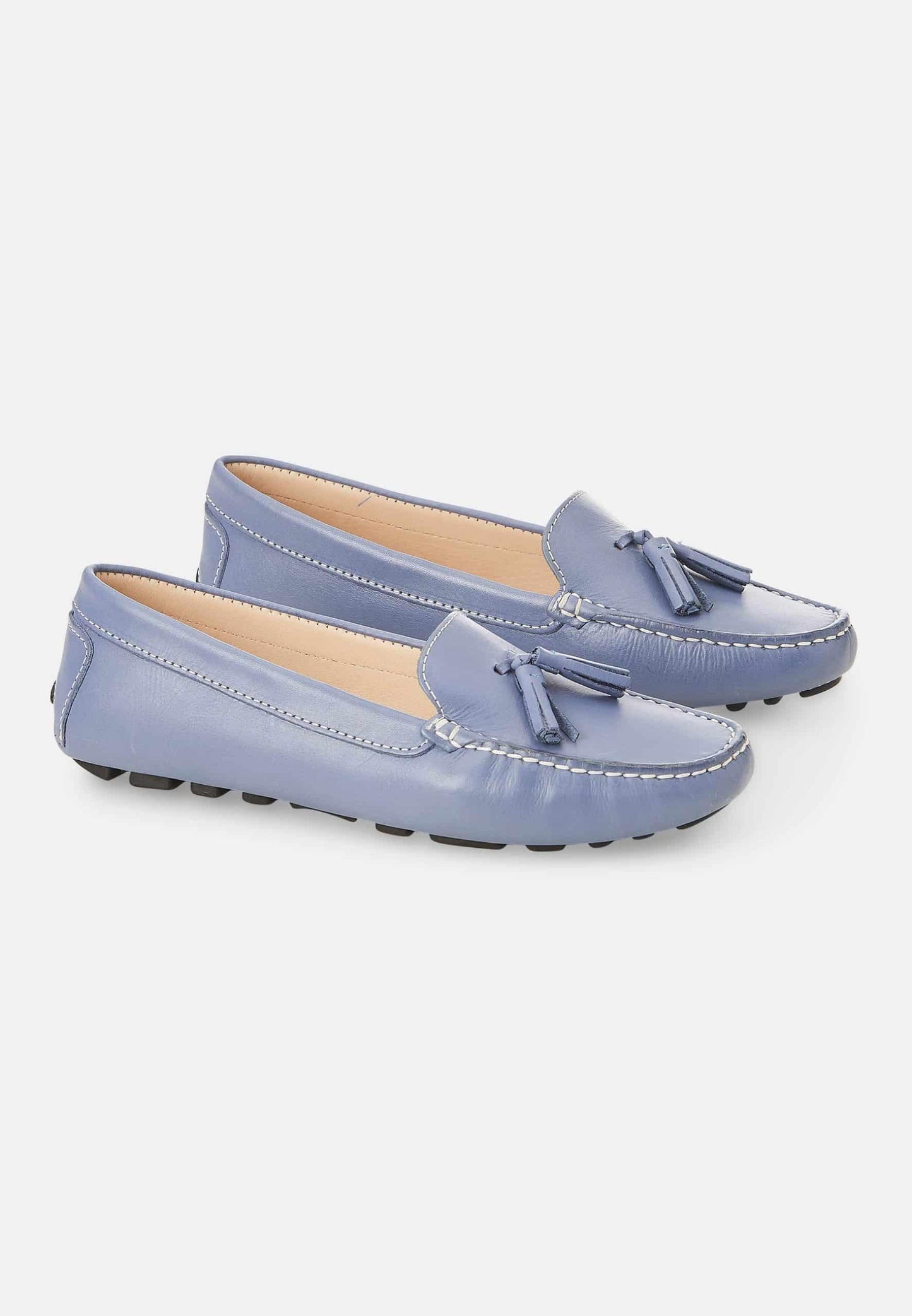 Pair of light blue loafers with tassels on a white background