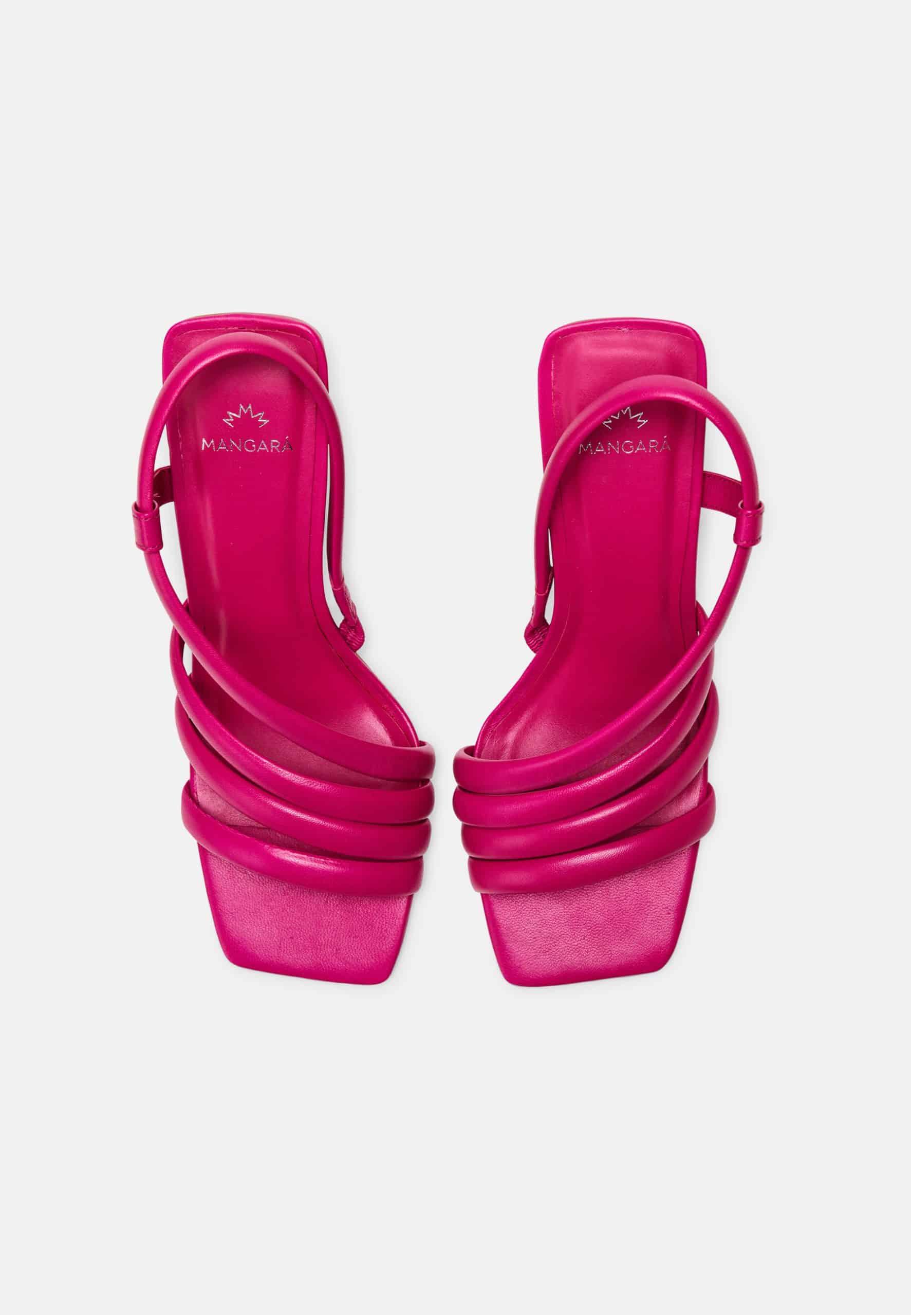 Pair of bright pink high-heeled sandals on a white background