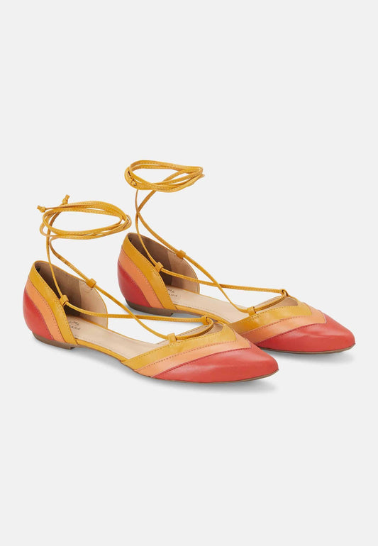 Yellow and red flat shoes with strappy design on a white background