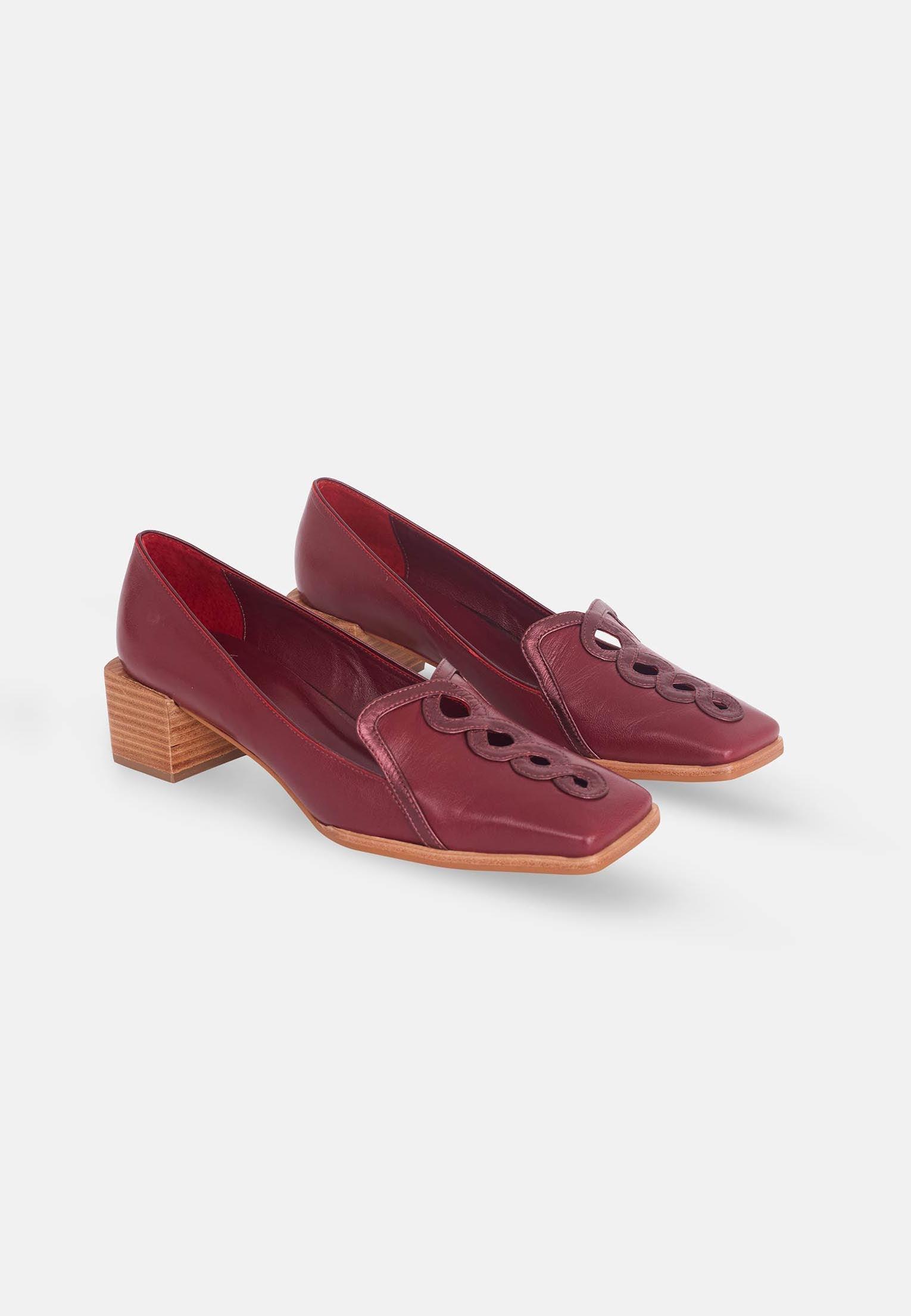 Pair of maroon shoes with wooden heel on a white background