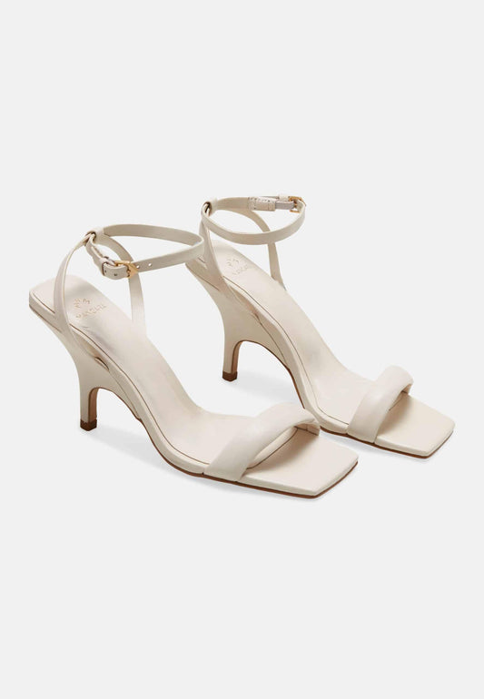 Pair of white high-heeled sandals on a white background