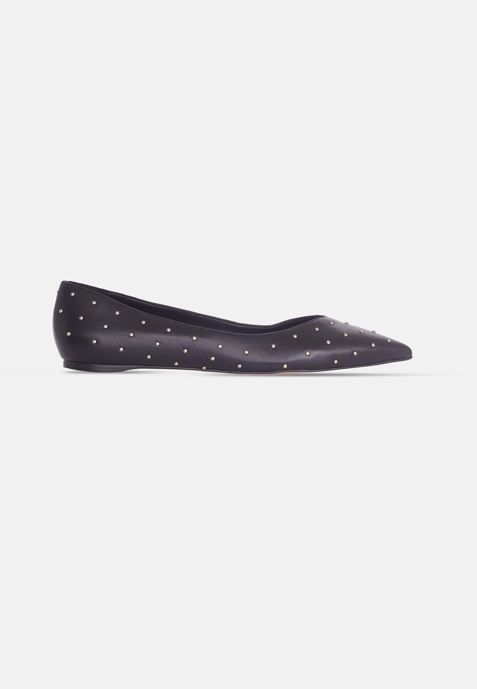 Black flat shoe with white polka dots on a light gray background